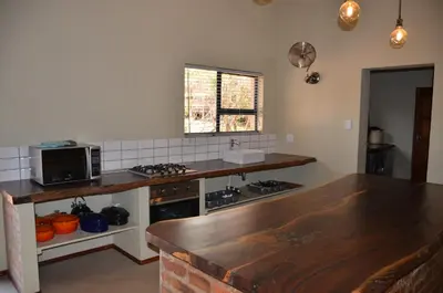 a kitchen with a counter top and a microwave at Stoep At Kruger in Komatipoort