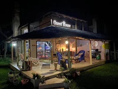 a gazebo with a guest house at night at The Aces - NUDE - SunEden Family Naturist Resort in Pretoria