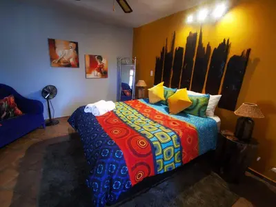 a bedroom with a bed with a colorful comforter at The Aces - NUDE - SunEden Family Naturist Resort in Pretoria