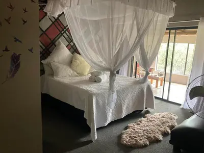 a bedroom with a white bed with a canopy at The Aces - NUDE - SunEden Family Naturist Resort in Pretoria