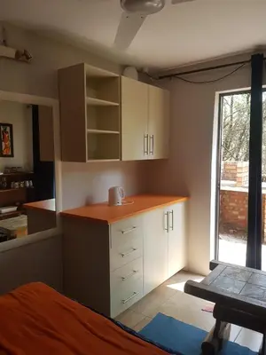 a small kitchen with white cabinets and a window at The Aces - NUDE - SunEden Family Naturist Resort in Pretoria