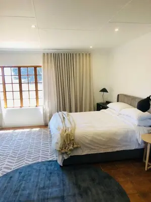 a bedroom with a large bed and a large window at Cipresso Guesthouse in Tierpoort