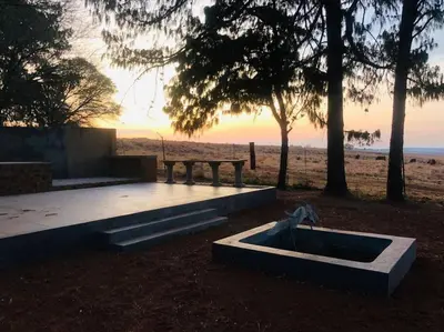a picnic table and a bench with the ocean in the background at Cipresso Guesthouse in Tierpoort