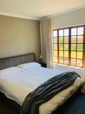 a bedroom with a large bed and a window at Cipresso Guesthouse in Tierpoort