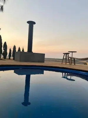 a pool of water next to a picnic table and a bench at Cipresso Guesthouse in Tierpoort