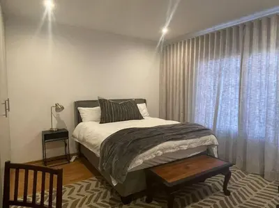 a bedroom with a large bed and a window at Cipresso Guesthouse in Tierpoort