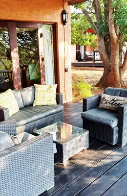 a porch with wicker furniture and a glass table at Bee-Eater Cottage, DaGama Dam in White River