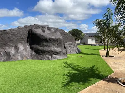 a large rock in a yard with green grass at Bluewave Farm Villa in Louis Trichardt