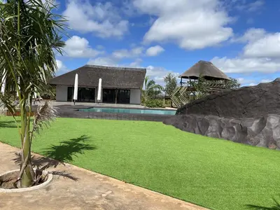 a house with a pool and a grass yard at Bluewave Farm Villa in Louis Trichardt