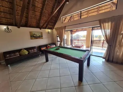 a living room with a pool table in it at Moshate Lodge Zebula 4 Bedroom Holiday home in Mabula