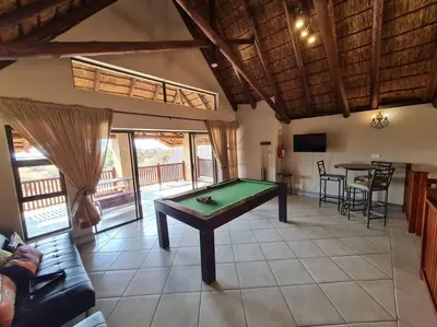 a living room with a pool table in it at Moshate Lodge Zebula 4 Bedroom Holiday home in Mabula