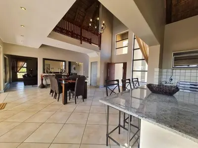 a large kitchen and living room with a table and chairs at Moshate Lodge Zebula 4 Bedroom Holiday home in Mabula