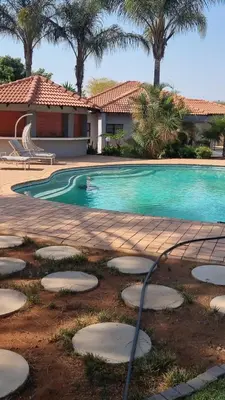 a swimming pool with a person in the water at Ultimate Sky in Pretoria