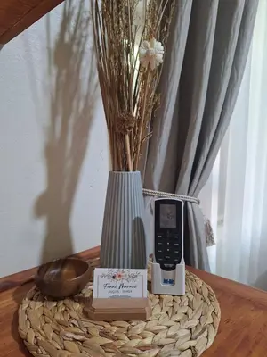 a table with a cell phone and a vase with flowers at Fraai Maraai Self Catering Apartments in Groblersdal