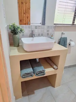 a bathroom with a sink on a counter with towels at Fraai Maraai Self Catering Apartments in Groblersdal