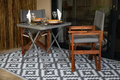 a table with two chairs and a table with bowls and plates at Braai Safaris Lodge in Hoedspruit