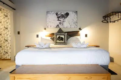 a bedroom with a bed with white flowers on it at Braai Safaris Lodge in Hoedspruit