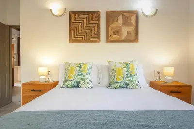 a bedroom with a white bed with two night stands at Eye of Kruger - Spacious holiday home with splash pool and boma in Marloth Park