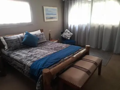 a bedroom with a bed and a chair and a window at Hawkshead Lodge in Alkmaar