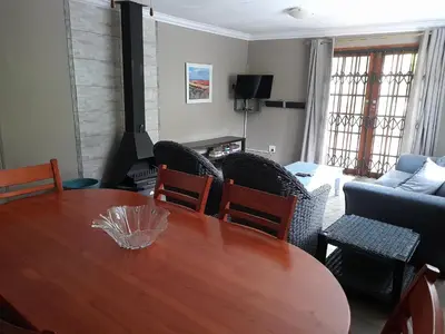 a living room with a wooden table and chairs at Hawkshead Lodge in Alkmaar
