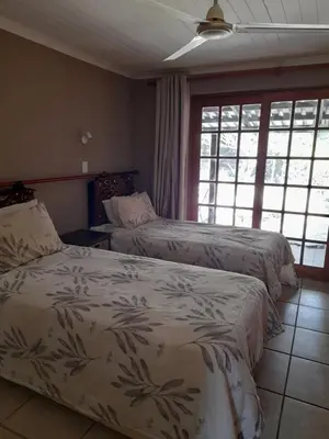 two beds in a room with windows at Hawkshead Lodge in Alkmaar