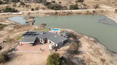 an overhead view of a house on a hill next to a lake at Casa de la Presa 4 in Polokwane