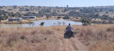 a man riding a motorcycle in a field at Casa de la Presa 4 in Polokwane