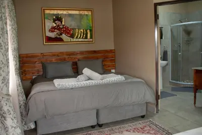 a bedroom with a bed and a bathroom with a shower at Casa de la Presa 4 in Polokwane