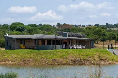 a house on a hill next to a body of water at Casa de la Presa 4 in Polokwane