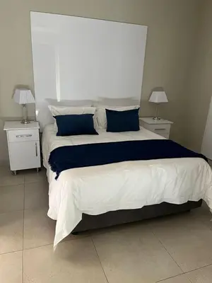 a bedroom with a large bed with blue and white sheets at Kanyane @ Graskop in Graskop