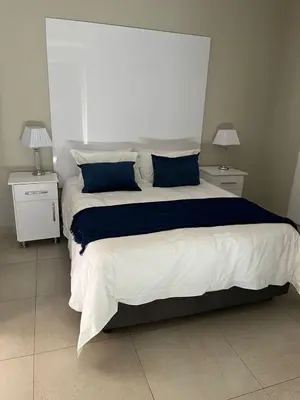 a bedroom with a large bed with blue and white sheets at Kanyane @ Graskop in Graskop