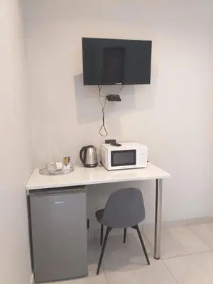 a white desk with a microwave and a tv at Kanyane @ Graskop in Graskop