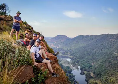 a group of people sitting on the edge of a mountain at Olifants River Lodge by Dream Resorts in Middelburg