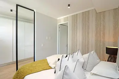 a bedroom with a white bed with white pillows at Ellipse Apartment in Midrand