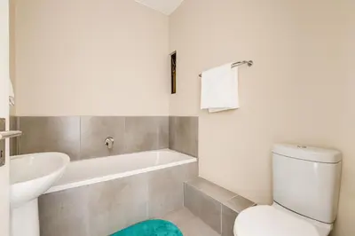a bathroom with a tub and a toilet and a sink at The Resting Nest Havilla in Midrand