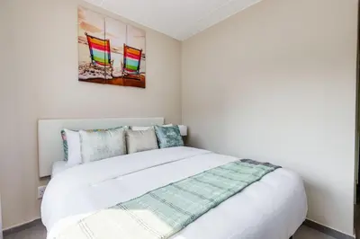 a bedroom with a white bed and a painting on the wall at The Resting Nest Havilla in Midrand