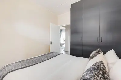 a bedroom with a large bed with white sheets at The Resting Nest Havilla in Midrand
