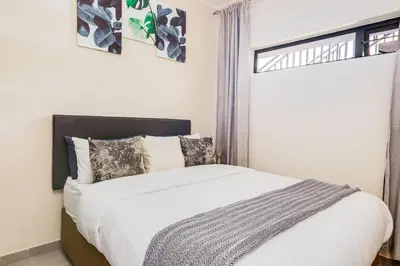 a bedroom with a large white bed with a window at The Resting Nest Havilla in Midrand