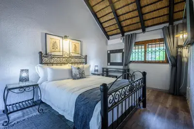 a bedroom with a large bed and a window at Kruger Park Lodge Unit No. 221 in Hazyview