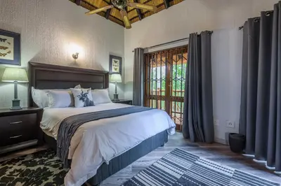 a bedroom with a large bed and a window at Kruger Park Lodge Unit No. 221 in Hazyview