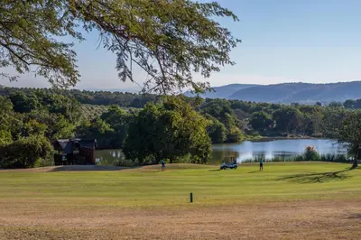 a golf course with a view of a lake at Kruger Park Lodge Unit No. 221 in Hazyview
