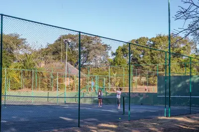 two people playing tennis on a tennis court at Kruger Park Lodge Unit No. 221 in Hazyview