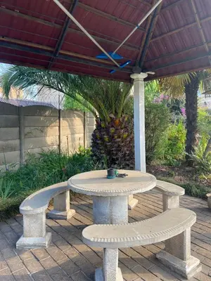 a table and two benches under an umbrella at Birch stay in Kempton Park