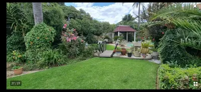 a garden with a bench and a gazebo at Birch stay in Kempton Park