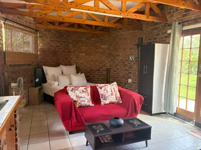 a bedroom with a bed in a brick wall at Birch stay in Kempton Park