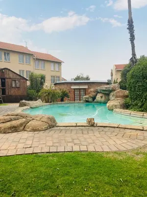 a swimming pool with rocks in a yard with a house at Birch stay in Kempton Park