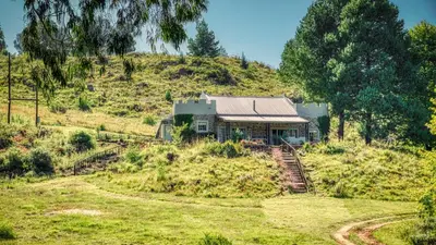 a house on the side of a hill at Trout Escape Farm in Dullstroom