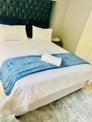 a bed with a blue blanket and a towel on it at The penthouse in Hartbeespoort