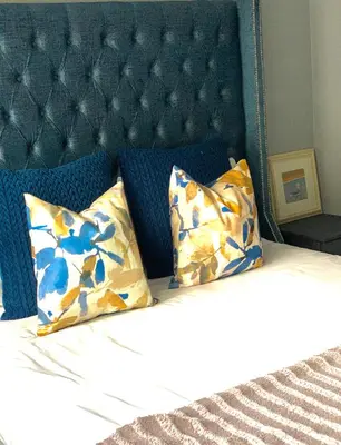 a bed with a blue headboard and two pillows at The penthouse in Hartbeespoort