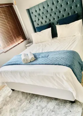 a bedroom with a large bed with towels on it at The penthouse in Hartbeespoort